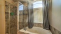 Pano Bathroom interior with round built in bathtub shower stall and warm toned tiles Royalty Free Stock Photo