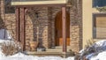 Pano Brown arched front door of home with stone brick wall in Park City neighborhood