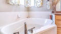 Pano Built in bathtub with stainless steel faucet inside bathroom with floral curtain