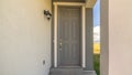 Pano Close up of home entrance with gray front door and lantern on the concrete wall Royalty Free Stock Photo
