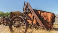 Pano Close up of an old and vintage tractor against wooden fence and light blue sky Royalty Free Stock Photo