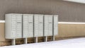 Pano Cluster metal mailboxes with pedestals against wall of building with snowy roof