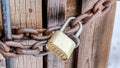 Pano Combination padlock and rusty iron chain securing the door of outdoor bathroom Royalty Free Stock Photo
