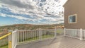 Pano frame Porch of a home overlooking the backyard and mountain under cloudy blue sky Royalty Free Stock Photo