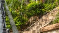 Pano frame Sunlit stone stairway with black metal railing and brick house background