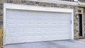 Pano Front door of home besiden white garage door under balcony overlooking driveway