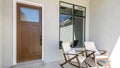 Pano Front porch with two rocking chairs and wooden door with glass panel