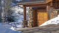 Pano Home exterior in Park City Utah against blue sky and snow dusted hill in winter Royalty Free Stock Photo