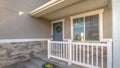 Pano Home facade with small porch and blue gray front door with green leafy wreath