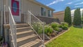 Pano Home with stairs going uo to the red front door against brick and concrete wall Royalty Free Stock Photo
