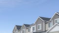 Pano Homes with gable roofs and gray exterior walls against blue sky in the suburbs Royalty Free Stock Photo