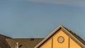 Pano House exterior with roof shingles and round gable window against blue sky Royalty Free Stock Photo