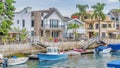 Pano Leaisure boats docked on canal in Long Beach neighborhood with resort like views Royalty Free Stock Photo