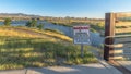 Pano No Jumping Warning sign at a shallow lake with trails and bridge on a sunny day