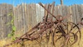 Pano Old vintage farming tractor against grasses and wooden fence on a sunny day