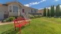 Pano Red metal bench on the front yard of a home against blue sky on a sunny day Royalty Free Stock Photo