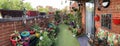 Pano of a roof top terrace with colourful flower pots and green grass