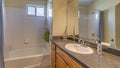 Pano Sink on marble countertop over brown cabinets against mirror and bathroom lights Royalty Free Stock Photo