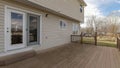Pano Spacious wooden deck of house overlooking the grassy backyard with playground Royalty Free Stock Photo