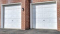 Pano White panelled garage doors of townhouses in the neighborhood on a sunny day