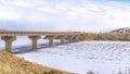 Pano White snow-covered river with a bridge and a white cloudy sky background