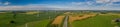 Panorama aerial view of countryside infrastructure with highway, windmills, agriculture fields. Royalty Free Stock Photo