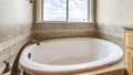 Panorama Alcove bathtub with antiqued marble tiles and deck mounted widespread faucet