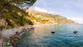 Panorama of amazing Positano cityscape on rocky landscape, people resting, swimming, fishing on the beach, boats are coming and Royalty Free Stock Photo