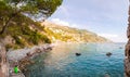 Panorama of amazing Positano cityscape on rocky landscape, people resting, swimming, fishing on the beach, boats are coming and Royalty Free Stock Photo
