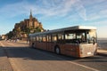 Panorama of ancient Mont Saint Michele abbey in a beautiful spring morning. Special bus brought first tourists to the Abbey.