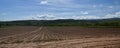 panorama of arable farming field that has been ploughed on sunny day with blue sky and white clouds Royalty Free Stock Photo