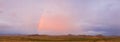 A panorama of an Arizona monsoon with a rainbow