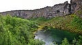 Panorama of Asbyrgisskogur forest and Botnstjorn lake surrounded by the vertical wall of Asbyrgi Glacial Canyon in Northern