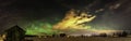 Panorama of Aurora and stars shine over abandoned shed standing alone in the field, deep autumn, winter and clear skies with come