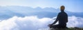 Panorama back view of man is relaxingly practicing meditation yoga mudra at mountain top with mist and fog in summer to attain