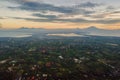 Bali with volcano, mountains, ocean and town with sunrise light. Aerial view