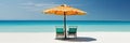 Panorama banner of two chairs and a sun umbrella on an exotic beach on a sunny day with blue water and sunny clear sky Royalty Free Stock Photo