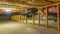 Panorama Basement or crawl space with upper floor insulation and wooden support beams Royalty Free Stock Photo