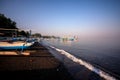 Panorama of a beach with boats and volcanic black sand in the North of Bali