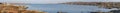 Panorama of Beach houses, Vegetation and rocks around Clifden bay Royalty Free Stock Photo