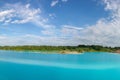 Panorama of a beautiful lake with azure-blue water. Green trees, blue sky. Summer s