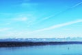 Panorama. Beautiful spectacular view over Bodensee. Calm water surface and snowy peaks of mountains on spring day. Travel to