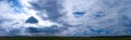 Panorama of Beautiful summer landscape. Countryside with road on the field, green grass, trees and dramatic blue sky with fluffy Royalty Free Stock Photo