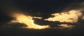 Panorama of a beautiful sunrise in the clouds. The sun's rays of golden yellow color pass through dark gray clouds