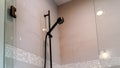 Panorama Black round shower head on tile wall of shower stall with hinged glass door