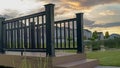 Panorama Bridge with wooden deck and black guardrail over a small and shiny pond