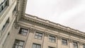 Panorama Building with decorative wall mouldings and shiny windows against cloudy sky Royalty Free Stock Photo