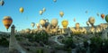 Panorama of bunch of colorful hot air balloon flying early morning in Cappadocia, Turkey against typical rock formation due to