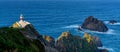 Panorama of the Cabo Ortegal lighthouse in Galicia with green cliffs and sunlight and deep blue ocean Royalty Free Stock Photo