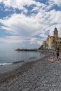 Panorama of the Camogli coast and rocky beach with people.